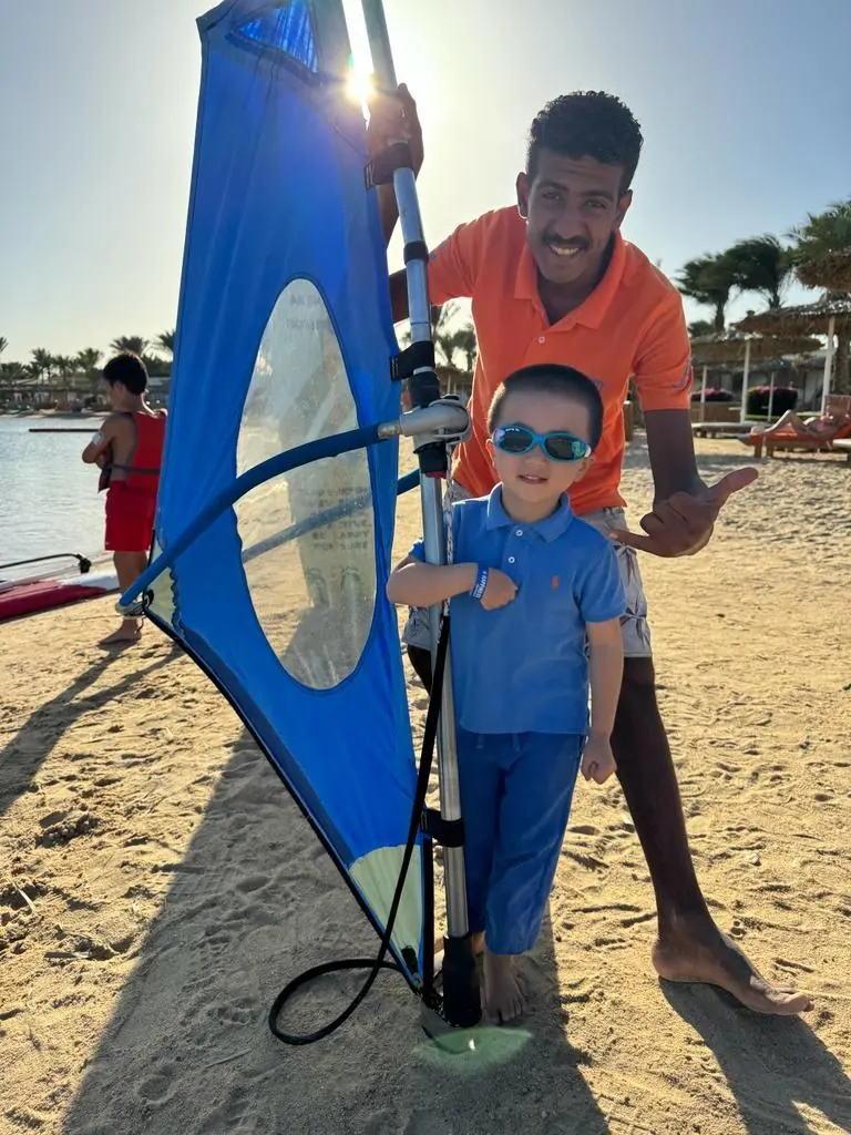 Windsurfing instructor with a young guest on the beach