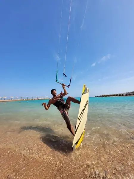 Instructor riding a kiteboard in shallow water