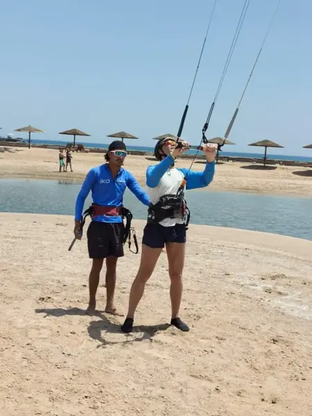 Instructor and guest practicing kite control on the beach